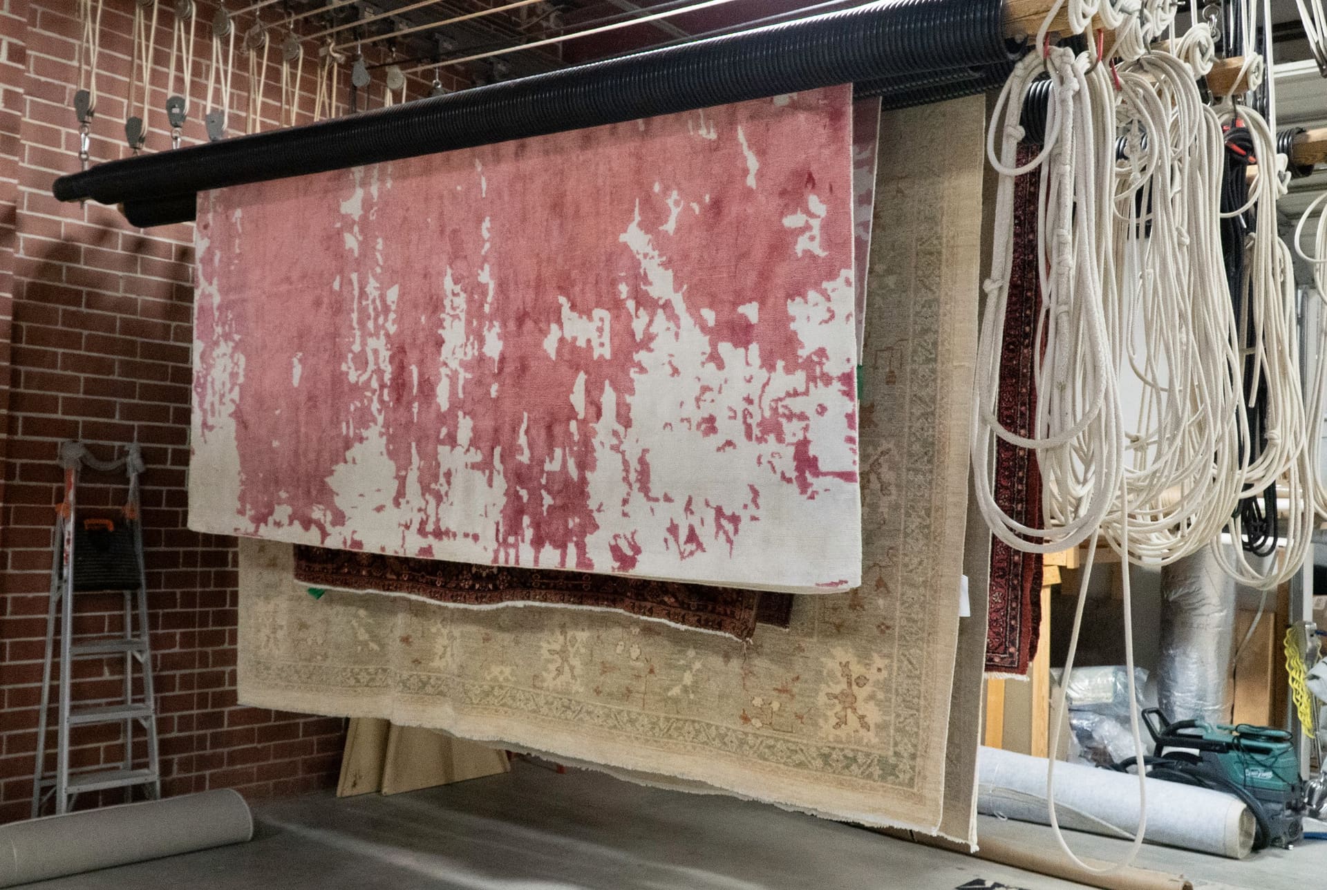 Area rugs drying in a climate-controlled environment at S&S Rug Cleaners before storage