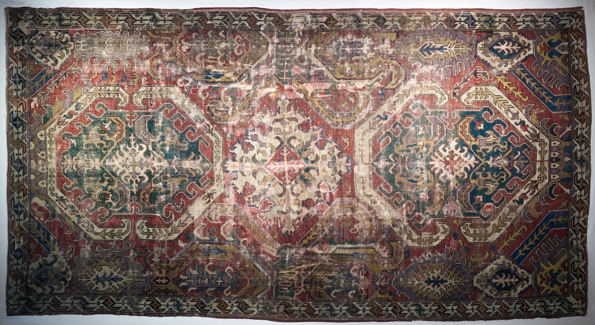 Richly detailed antique rug featuring exquisite geometric designs and a vintage aesthetic