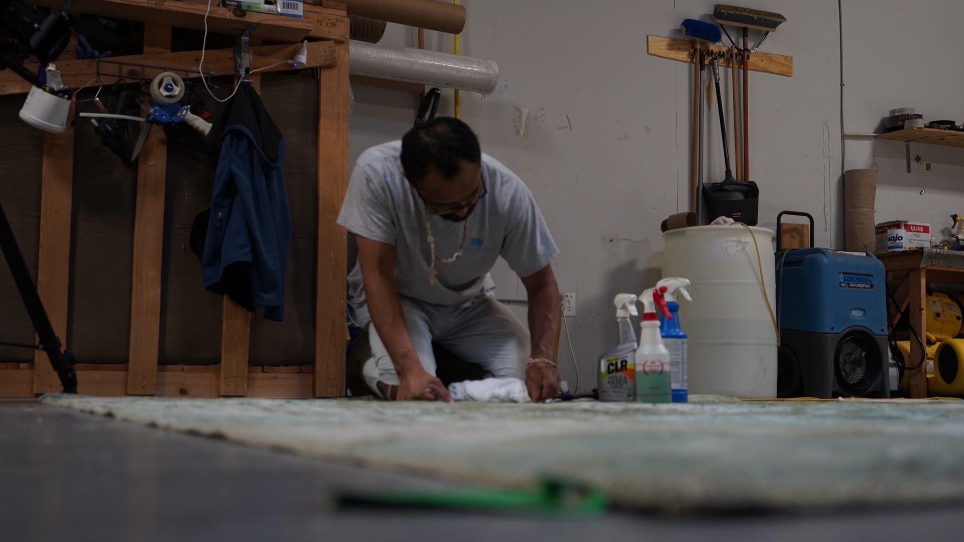 S&S Rug Cleaners technician spot treating a stain on a wool area rug by hand with a white cloth