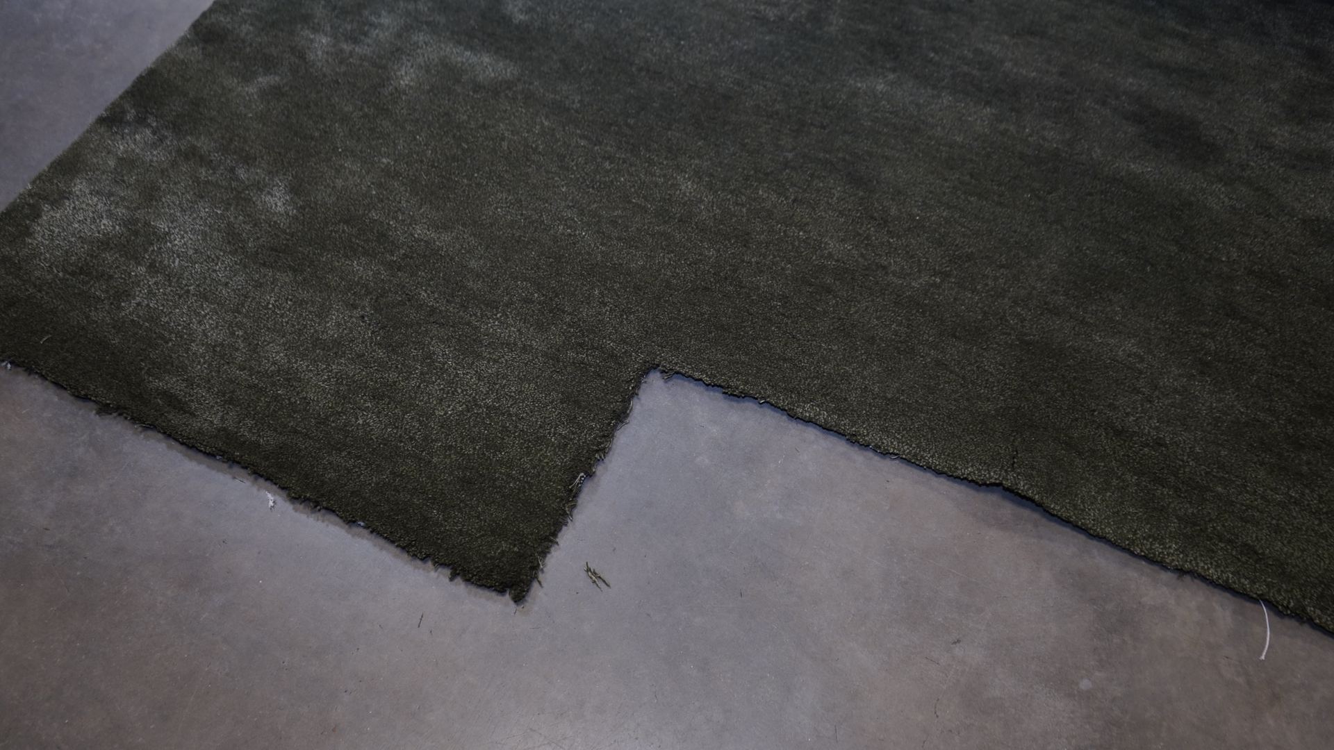 Close-up of a green viscose area rug showing the light-reflecting sheen and soft pile that make viscose rugs hard to clean